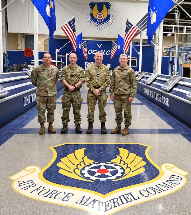 4 men standing next to each other in military uniforms
