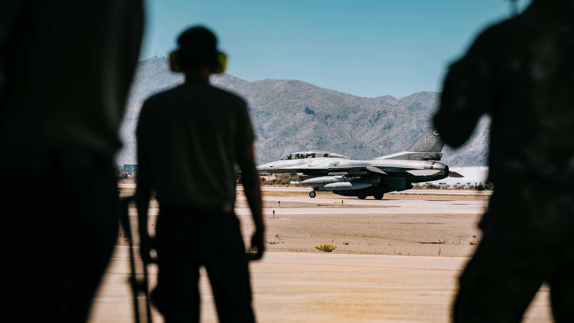 U.S. Air Force 56th Fighter Wing Airmen watch the final U.S. F-16 taxis to the runway.