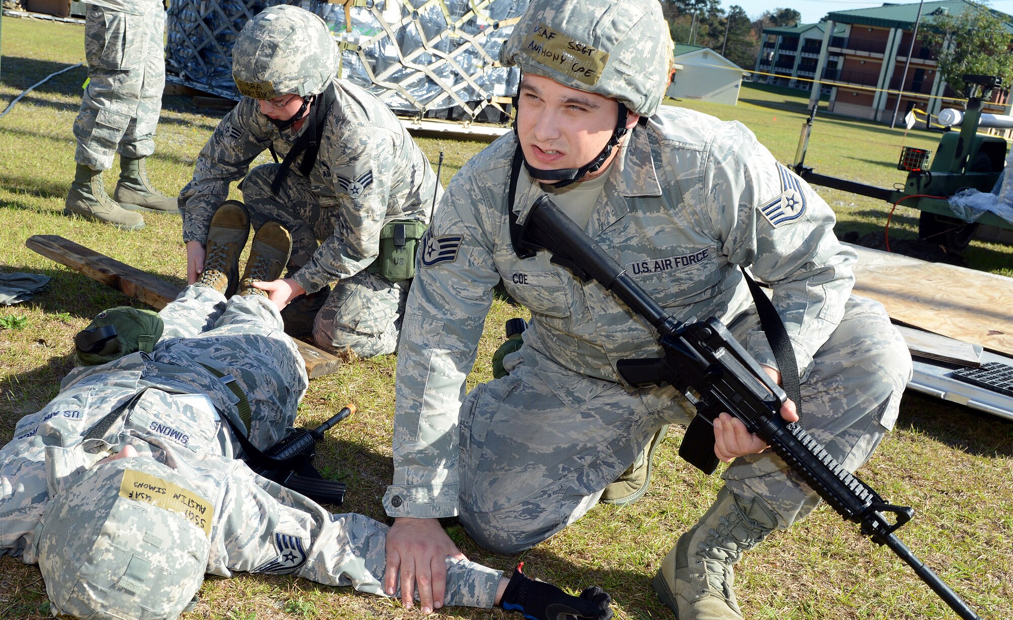 Staff Sgt. Anthony Coe, RF Transmission Systems supervisor (front), and Senior Airman Zachary Blucker, 51st Combat Communications Squadron, render self-aid and buddy care to Staff Sgt. Austin Simons, RF Transmission Systems supervisor, following a simulated attack