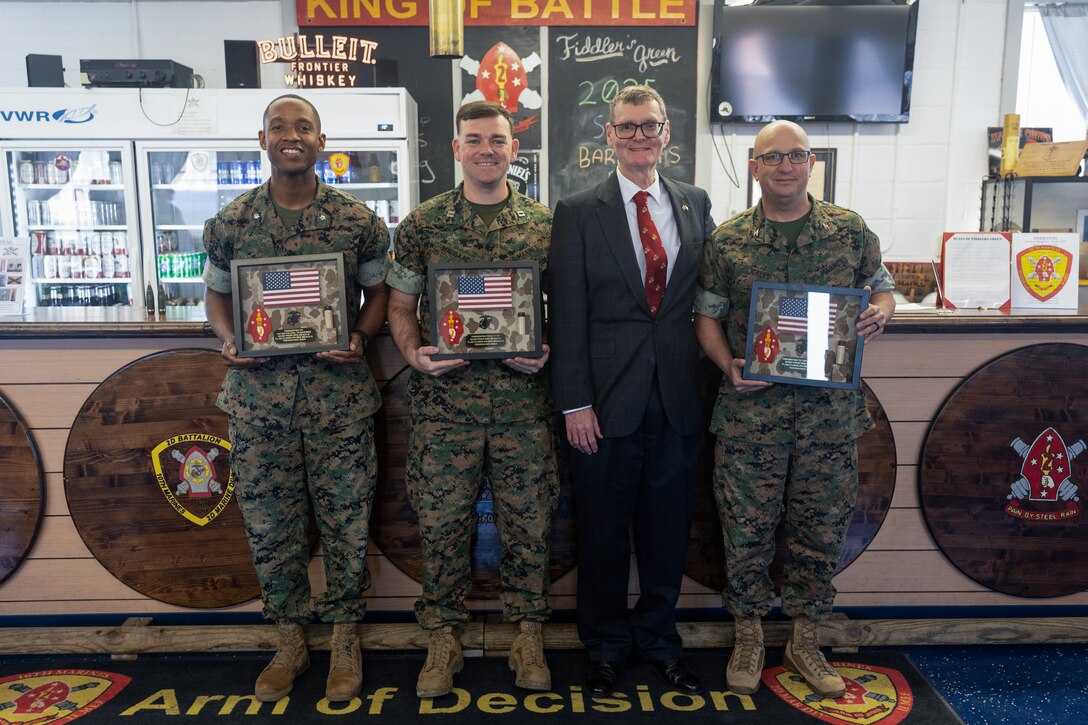 U.S. Marine Corps leaders with 10th Marine Regiment, 2d Marine Division pose for a photo with retired U.S. Marine Corps Maj. John Turner Jr. during a ceremony on Marine Corps Base Camp Lejeune, March 21, 2025. During the ceremony, Turner presented shadow boxes in honor of his father who served during World War II, including the battle of Tarawa; the vial of sand honors the legacy of the Marines who gave their lives during the Battle of Tarawa. (U.S. Marine Corps photo by Cpl. Grace Stover)