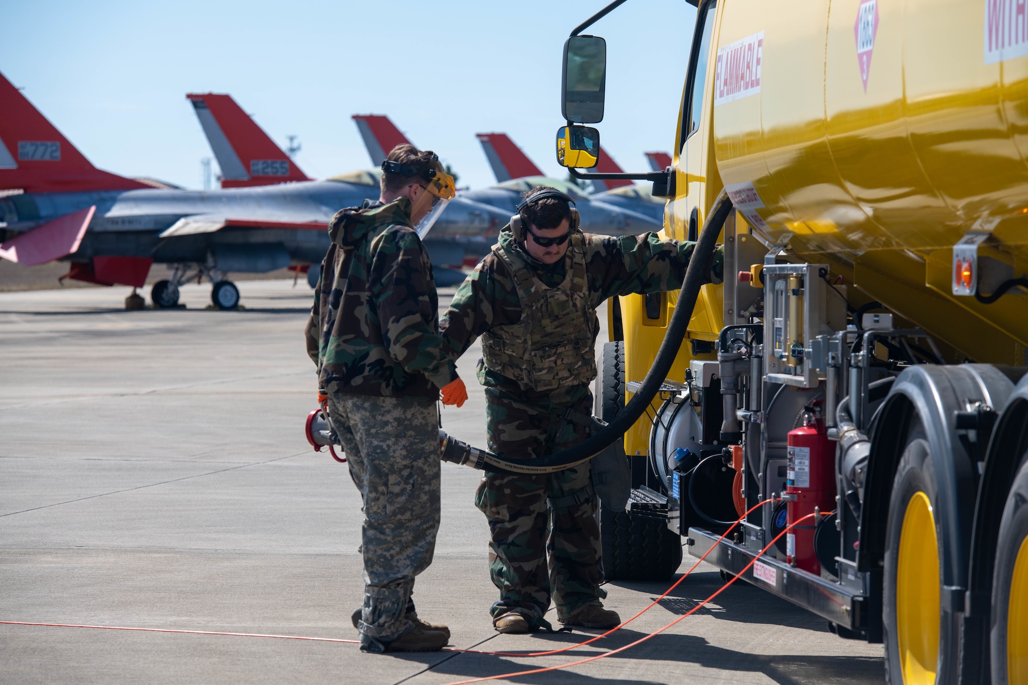 Two Airmen stand on the flightline