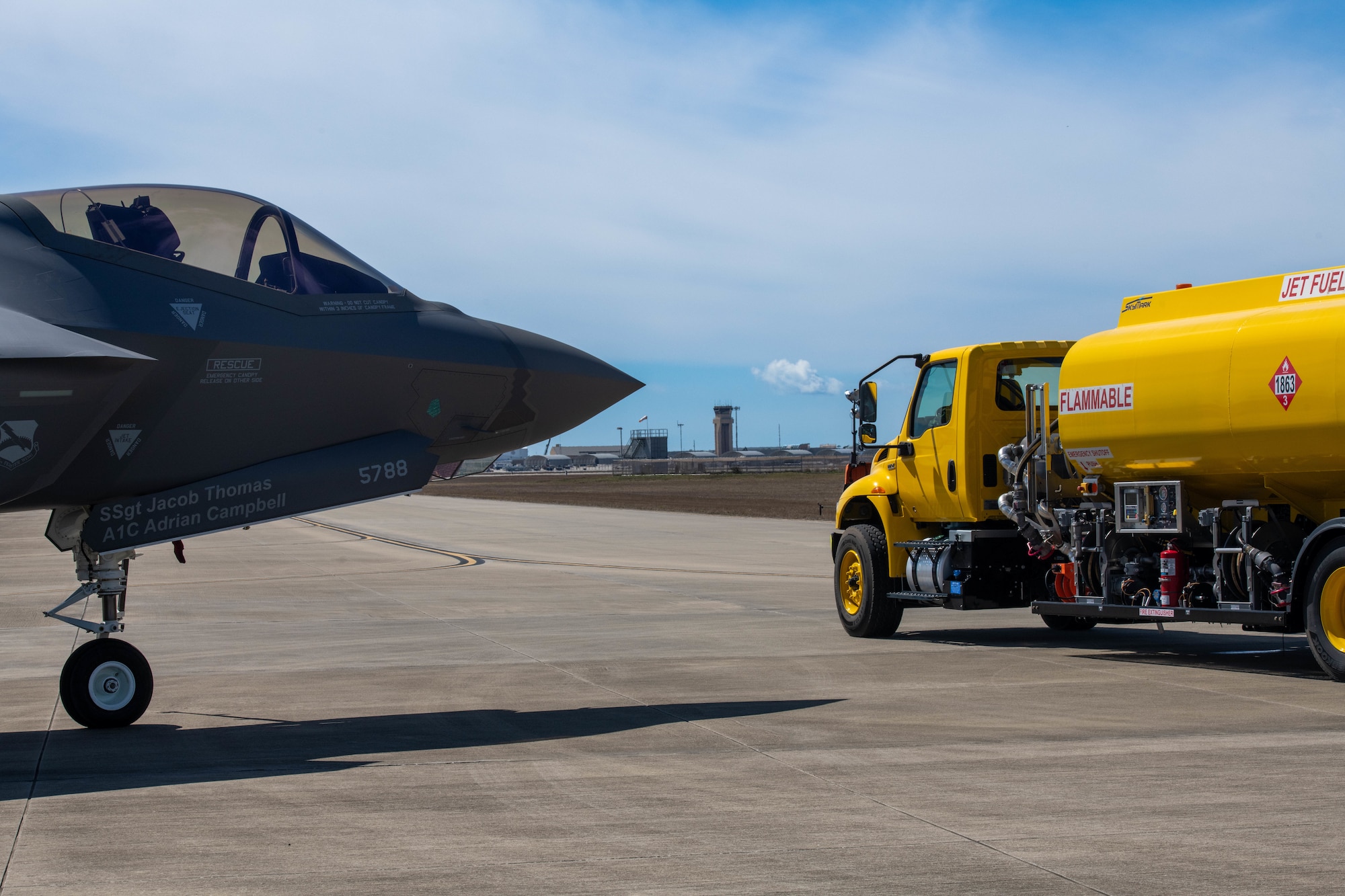An aircraft and fuel truck sit on the flight line