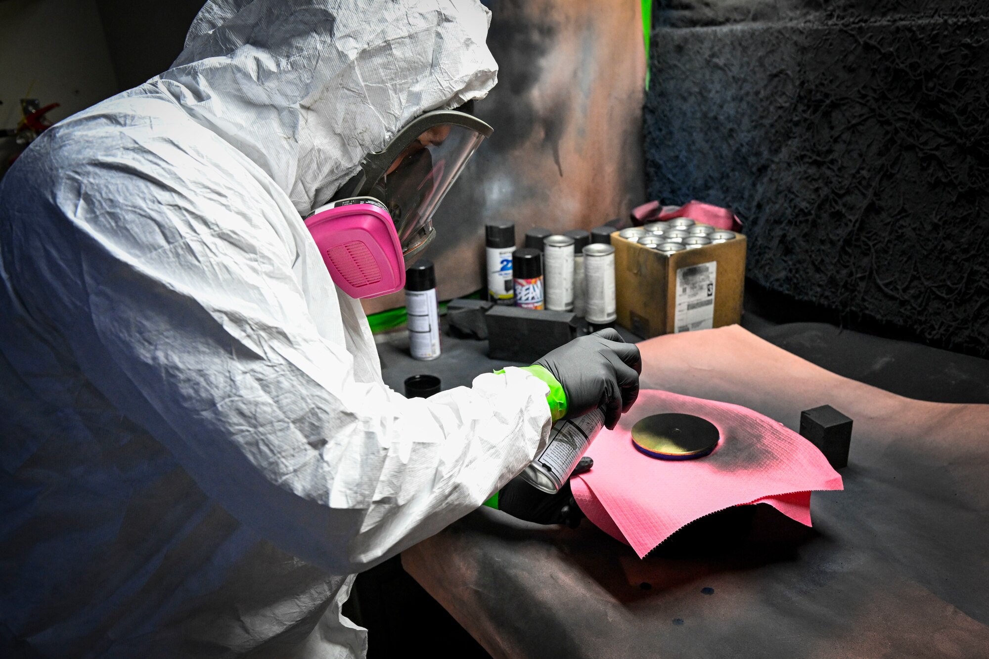 An Airman applies protective coating to an object.