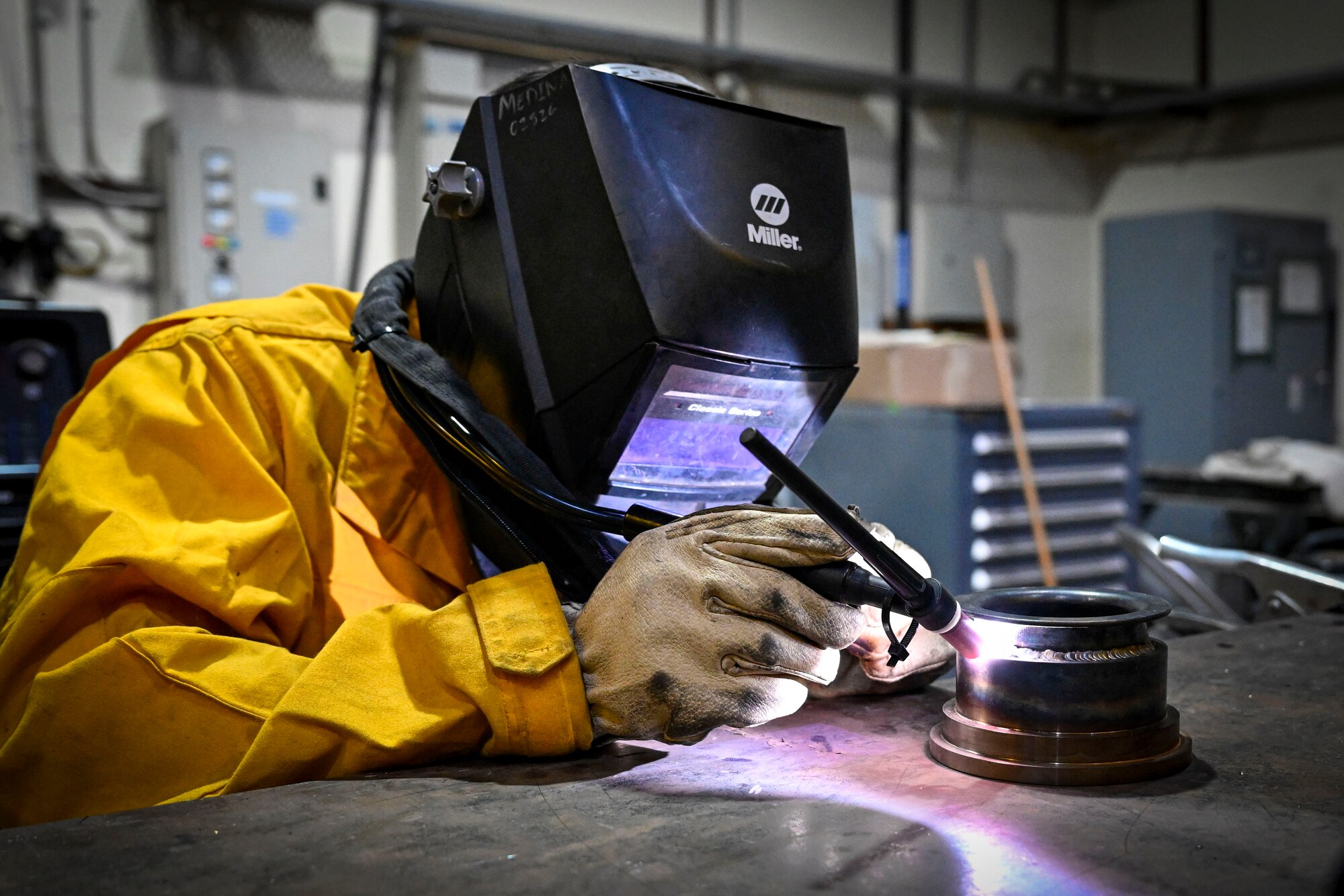 An Airman welds a portion of an emergency water shut off valve.