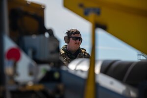 An Airman monitors fuel being pumped into an aircraft