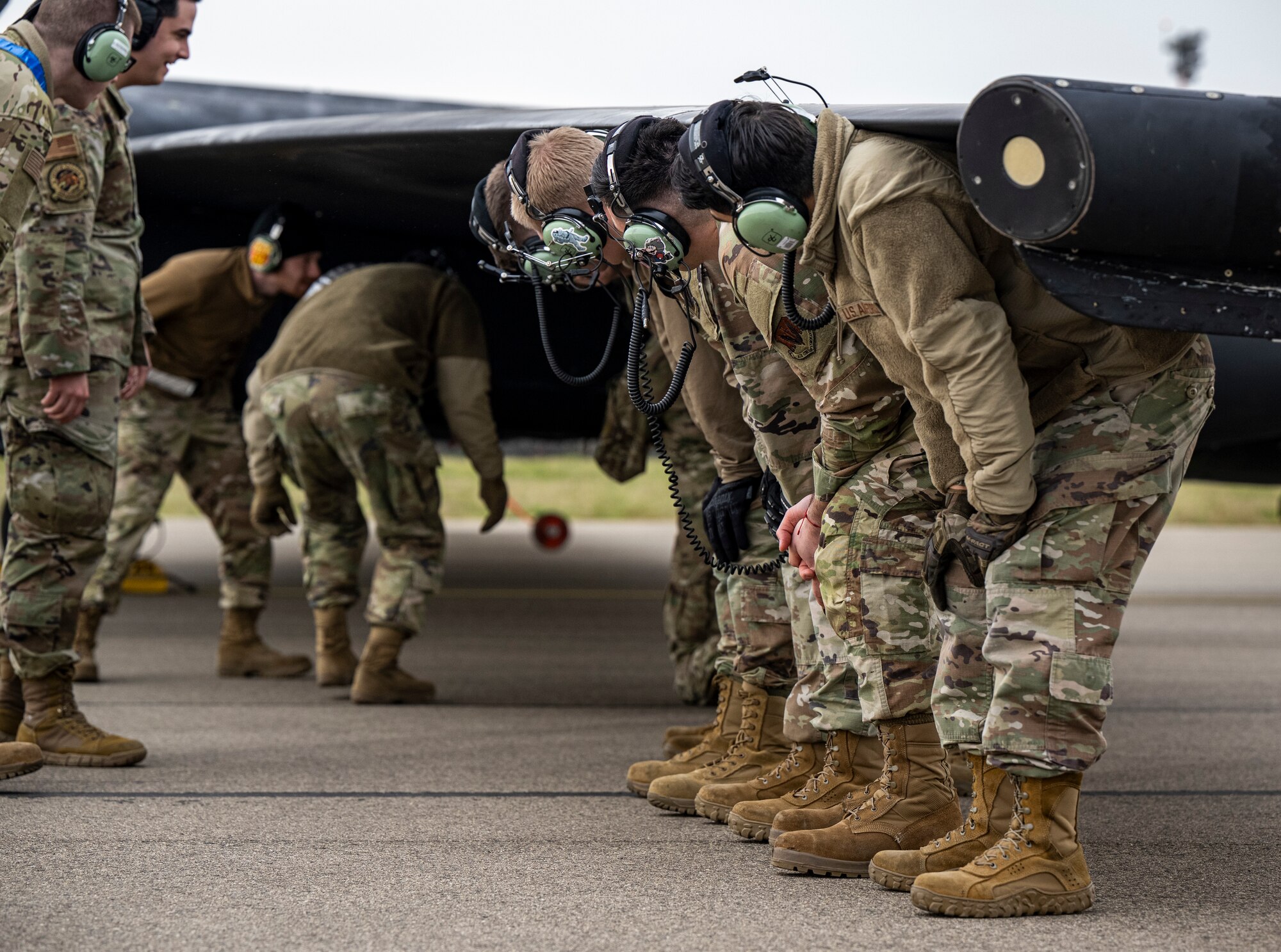 U.S. Airmen assigned to the 95th Reconnaissance Squadron hold up the wing of a U-2 Dragon Lady during divert training at RAF Mildenhall, England, March 25, 2025.