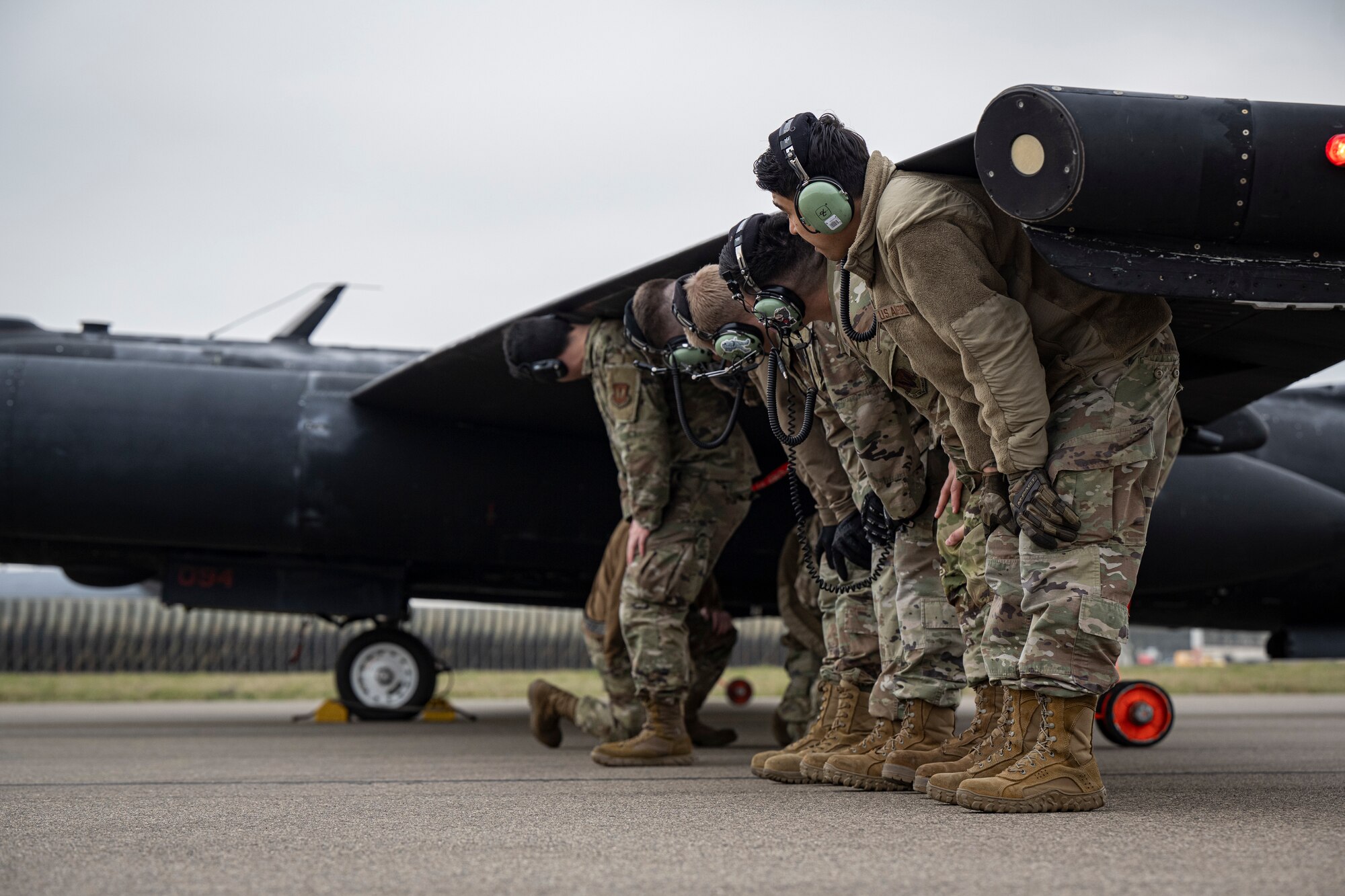 U.S. Airmen assigned to the 95th Reconnaissance Squadron hold up the wing of a U-2 Dragon Lady during divert training at RAF Mildenhall, England, March 25, 2025.