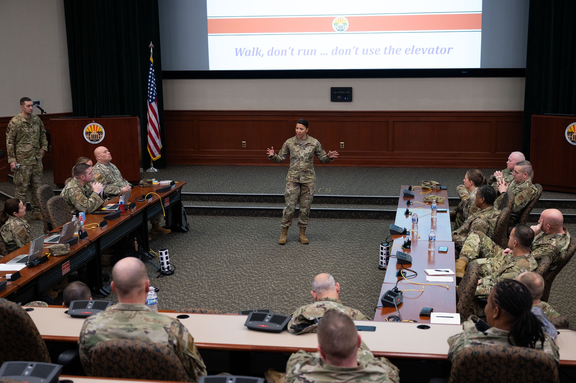 An airman speaks to a group.