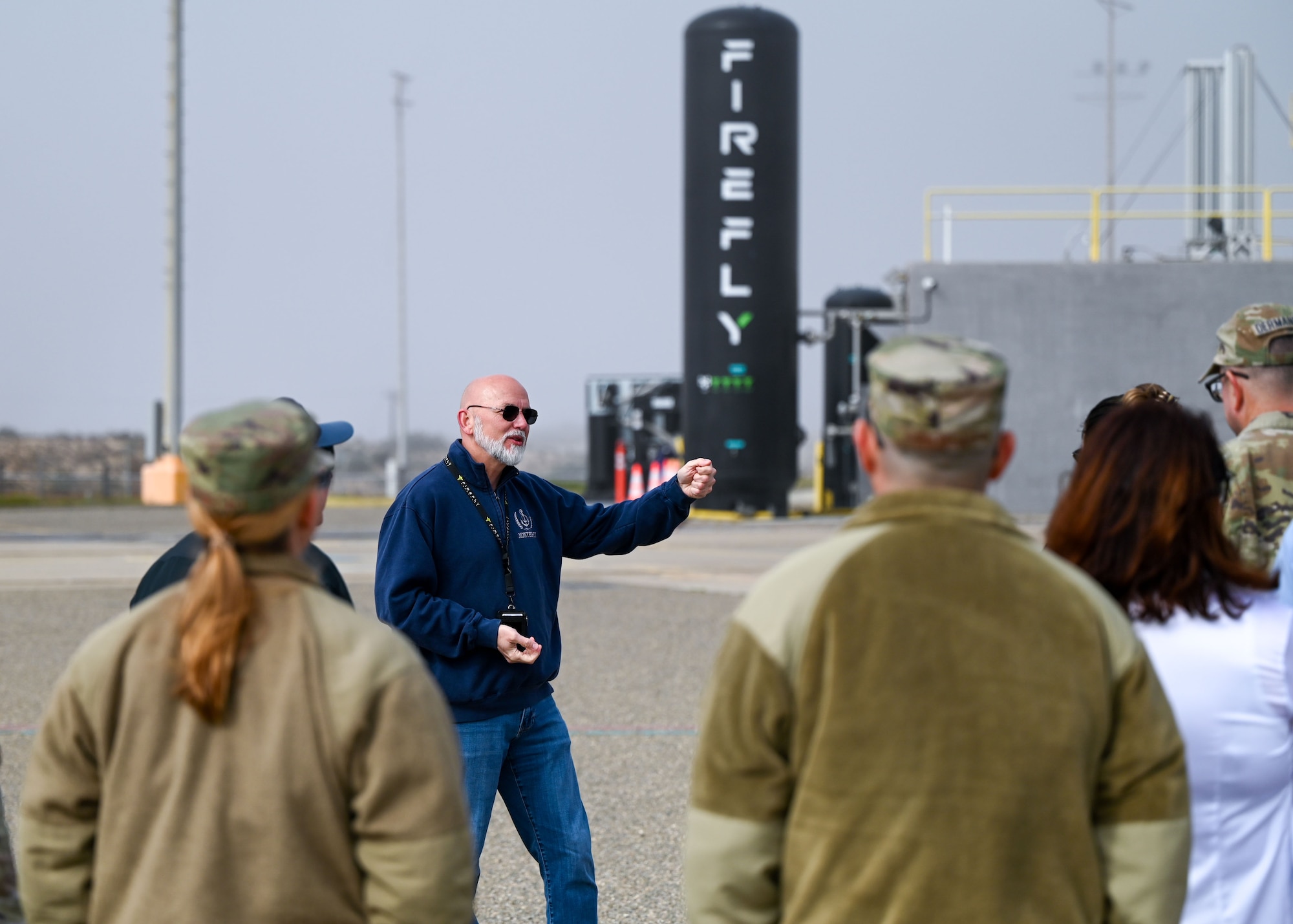 A man talks to a group of people outside.