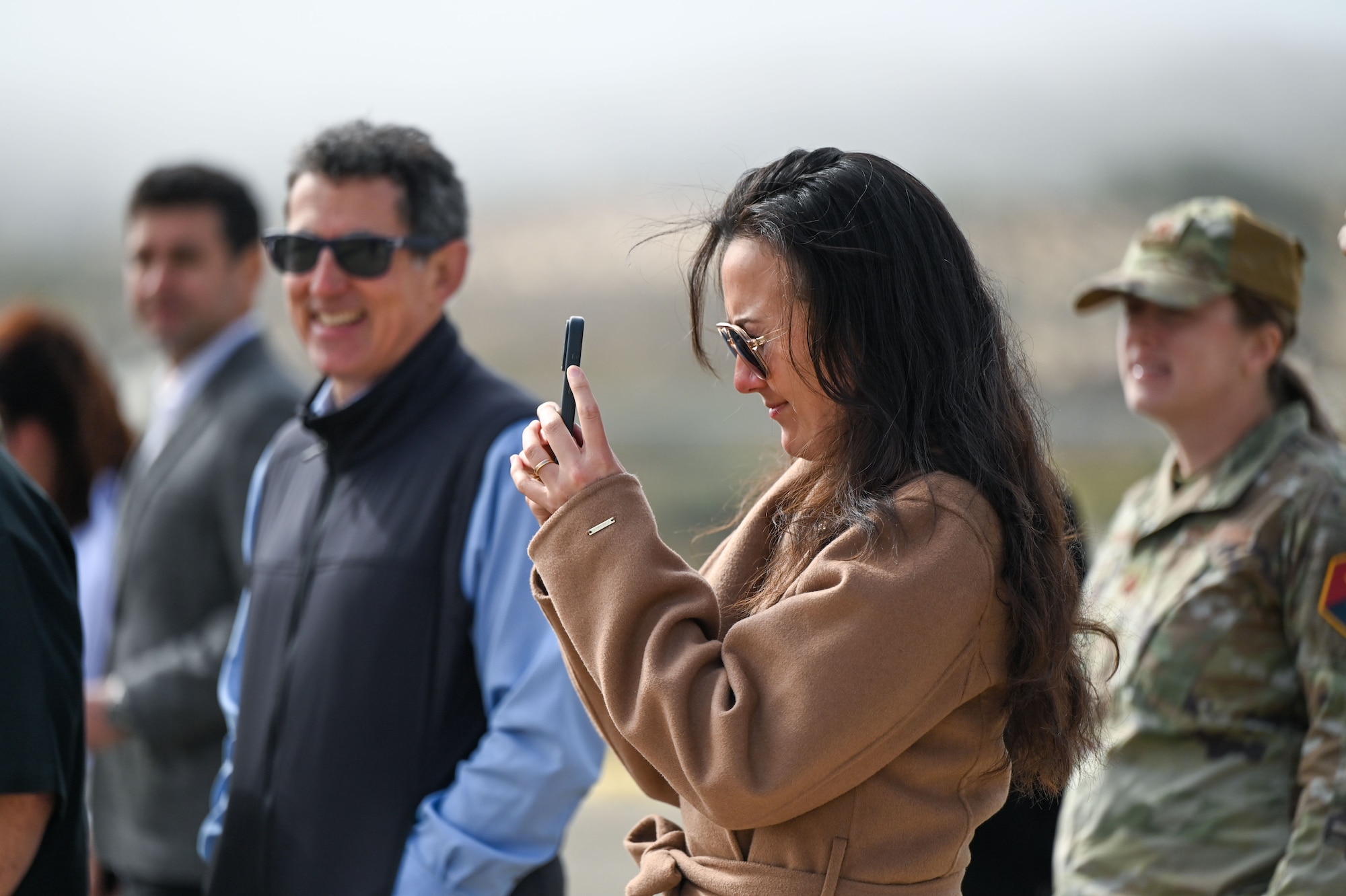 A woman takes a picture outside.