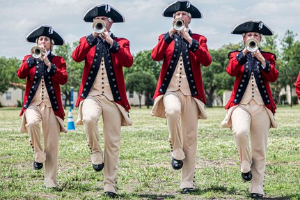 four personnel marching playing bugels