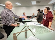 Robert Nance, trade instructor, Shop 11, Shipfitters, talks with Jenean Valencia, electroplater helper, Shop 31, Inside Machinist, March 19, 2025, during the Apprentice Program Knowledge Fair at Puget Sound Naval Shipyard & Intermediate Maintenance Facility in Bremerton, Washington. (U.S. Navy photo by Wendy Hallmark)