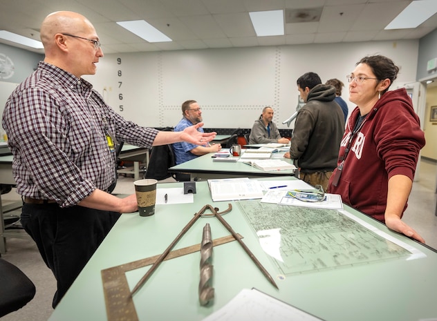 Robert Nance, trade instructor, Shop 11, Shipfitters, talks with Jenean Valencia, electroplater helper, Shop 31, Inside Machinist, March 19, 2025, during the Apprentice Program Knowledge Fair at Puget Sound Naval Shipyard & Intermediate Maintenance Facility in Bremerton, Washington. (U.S. Navy photo by Wendy Hallmark)