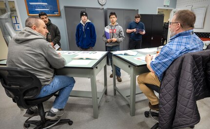 Jamie Slaughter, instructor, Shop 17, SheetMetal, and Tony Brown, apprentice manager, Shop 11/17, Metal Forge and SheetMetal, talk with command employees about the Puget Sound Naval Shipyard & Intermediate Maintenance Facility Apprentice Program, in Bremerton, Washington. (U.S. Navy photo by Wendy Hallmark)