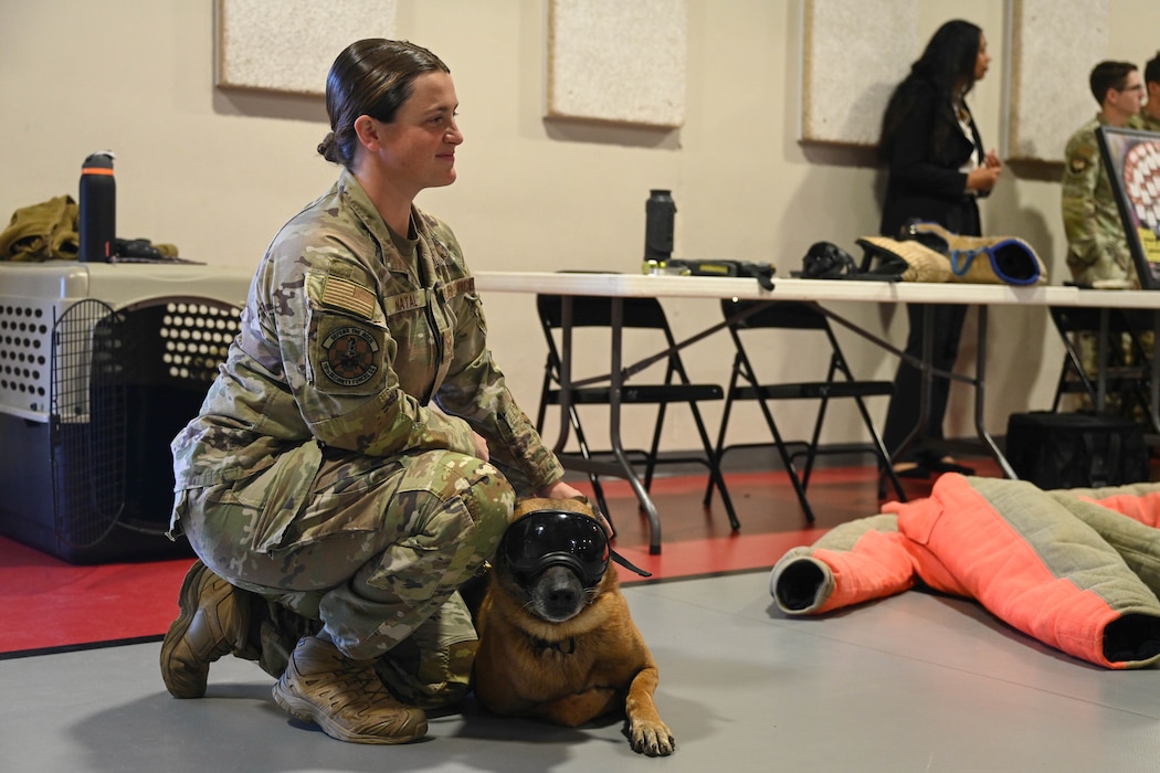 A woman and her dog talk in front of students.