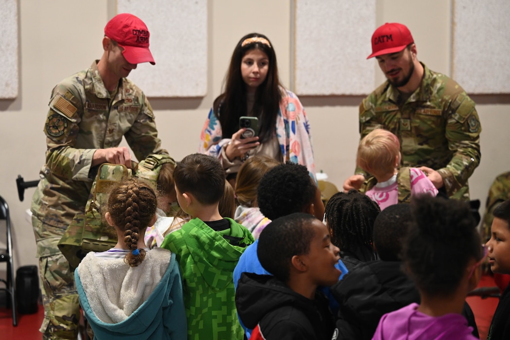Two men teach students about the military.
