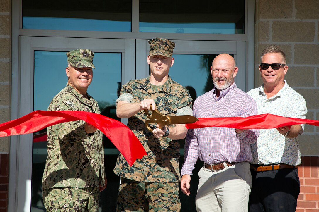 U.S. Navy Capt. Miguel Dieguez, commanding officer of Navy Facilities Southeast, joins Marine Corps Col. Luke Watson, commanding officer of Blount Island Command, in cutting a ribbon March 26 at Marine Corps Support Facility Blount Island in Jacksonville, Florida. A new $14.2 million police station and emergency operations center opened on the facility, consolidating vital functions into a single, hardened structure and enhancing protection for Marine Corps' prepositioning programs. The up to date, 18,500-square-foot building combines the former police station and emergency operations center, which had been in structures vulnerable to hurricanes.