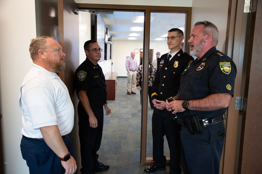 John Roberts, interim emergency manager and critical infrastructure protection officer, speaks with Joe Cowan, patrol and enforcement director, Jacksonville Sheriff’s Office, after a ribbon-cutting ceremony March 26 at Marine Corps Support Facility Blount Island in Jacksonville, Florida. A new $14.2 million police station and emergency operations center opened on the facility, consolidating vital functions into a single, hardened structure and enhancing protection for Marine Corps' prepositioning programs. The up to date, 18,500-square-foot building combines the former police station and emergency operations center, which had been in structures vulnerable to hurricanes.