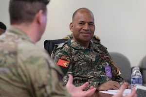 Foreign national visitor from Falintil - Forcas de Defesa de Timor-Leste speaks to a U.S. Air Force Airman.