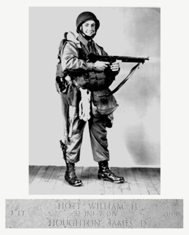 A man in 1940s-era military fatigues is standing and posing for the camera while holding a rifle.