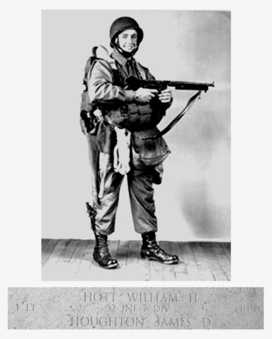 A man in 1940s-era military fatigues is standing and posing for the camera while holding a rifle.