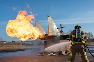 A firefighter puts out a simulated fire