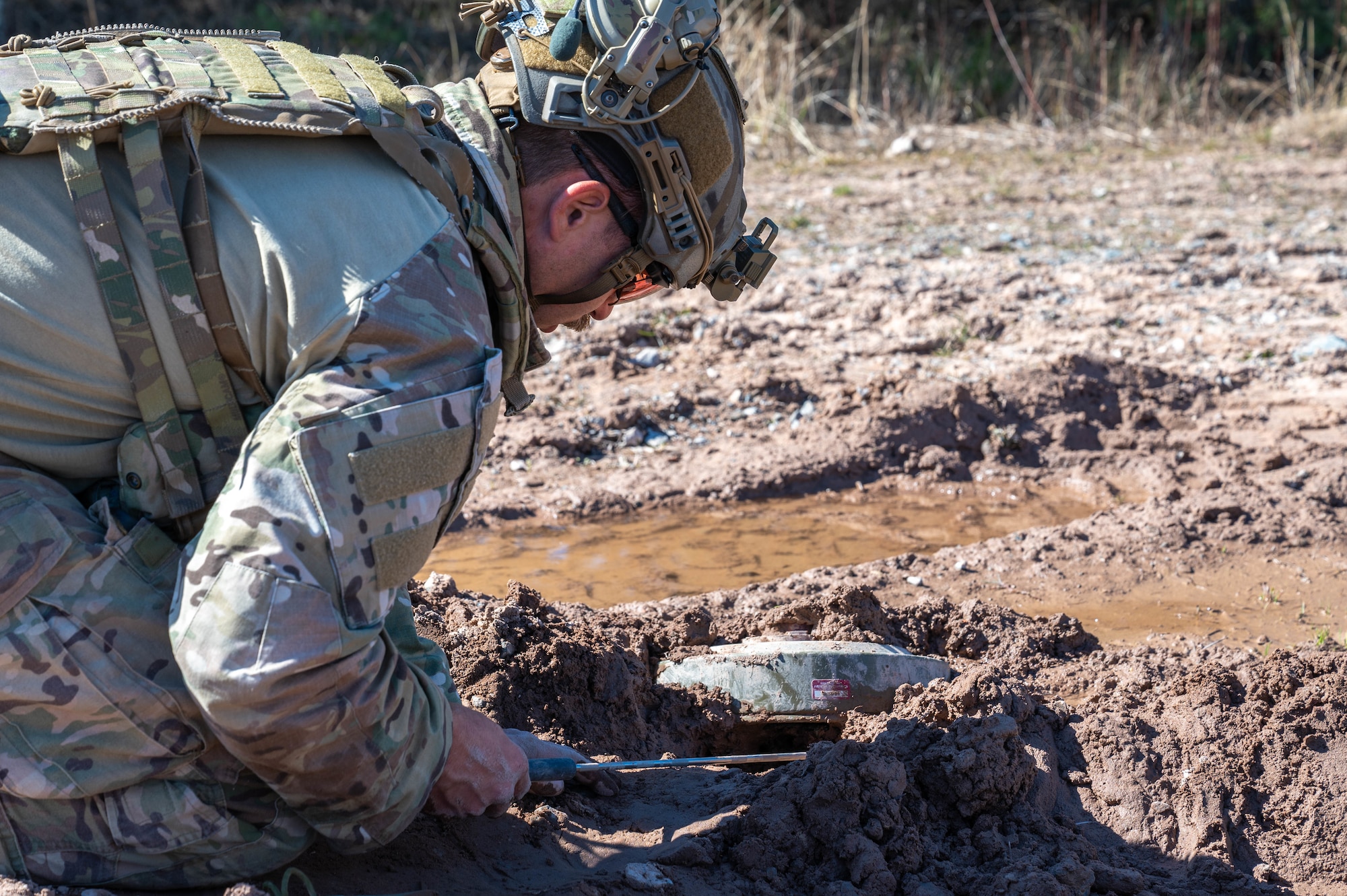 A man inspects a simulated landmine