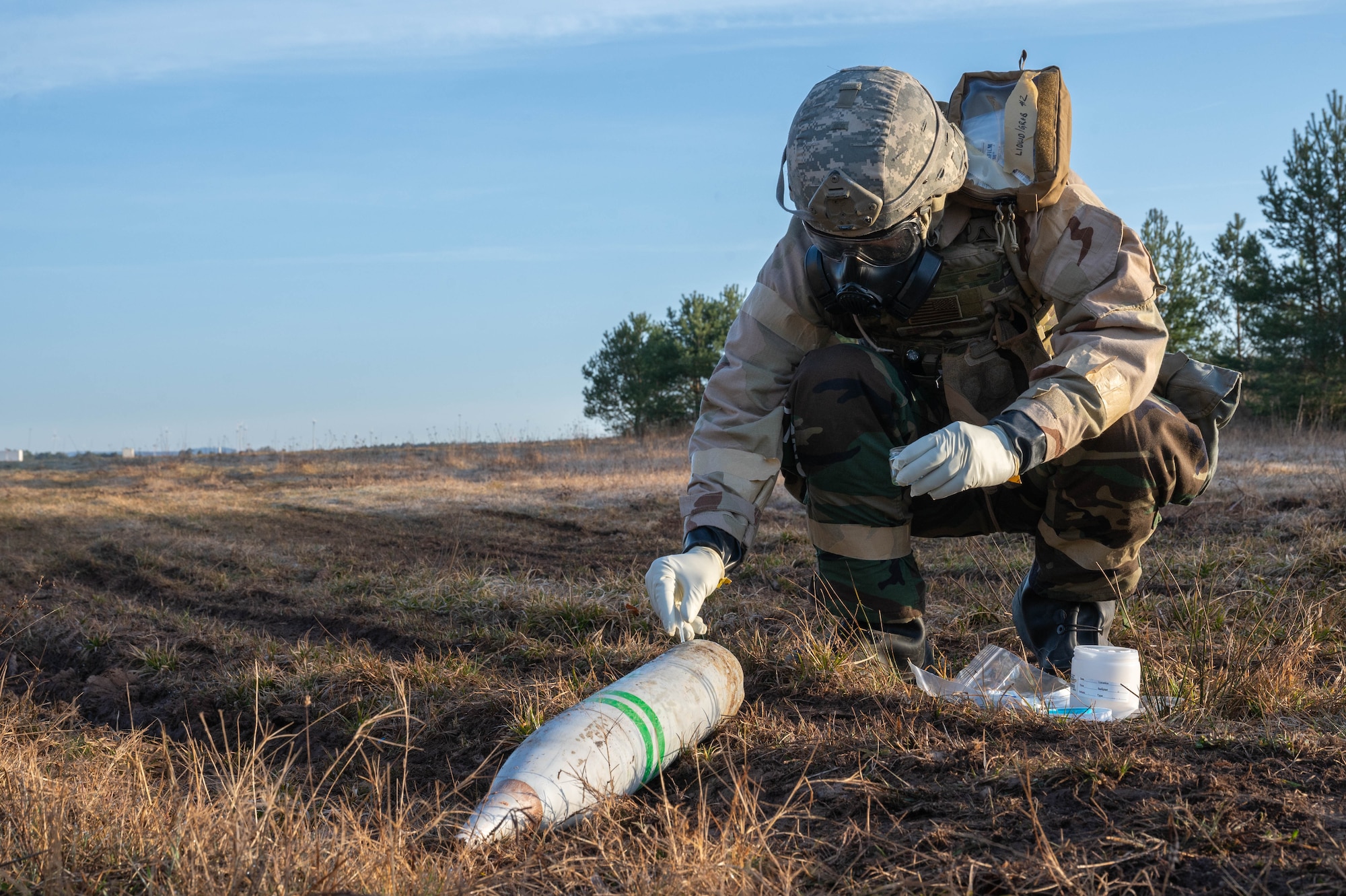 A man takes a sample from a simulated unexploded ordnance