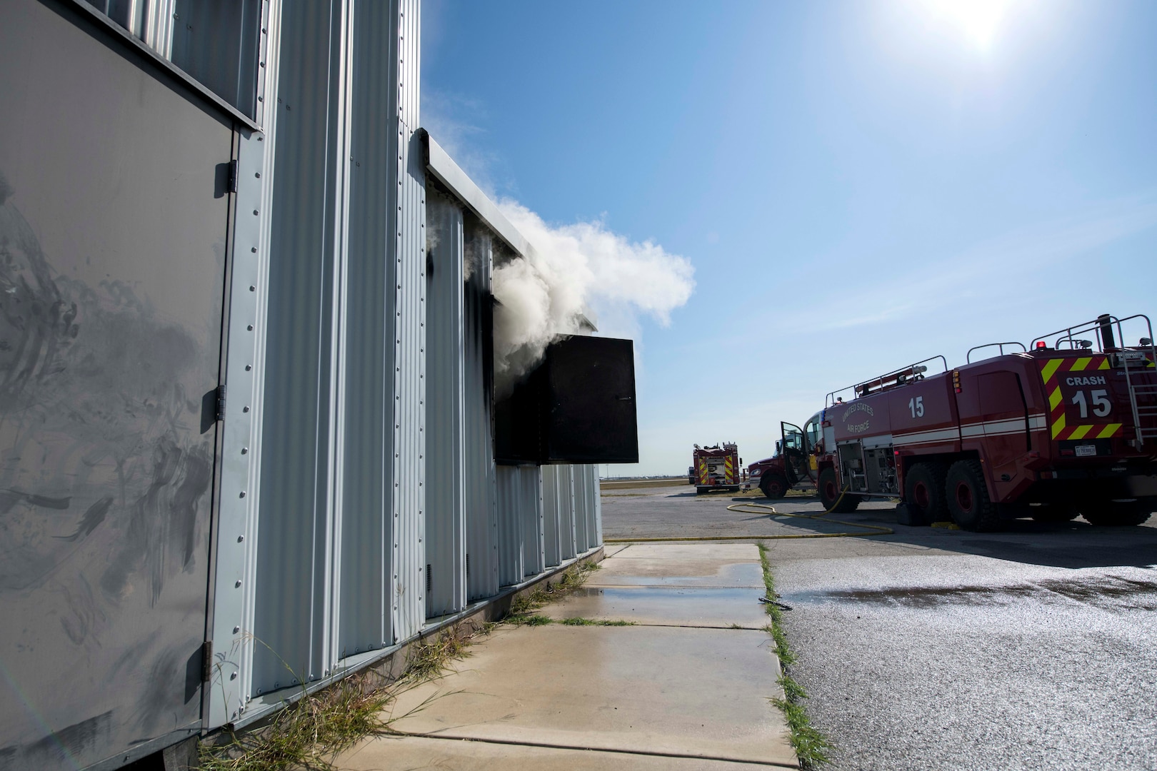 smoke flows out a window of a training container