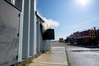 smoke flows out a window of a training container
