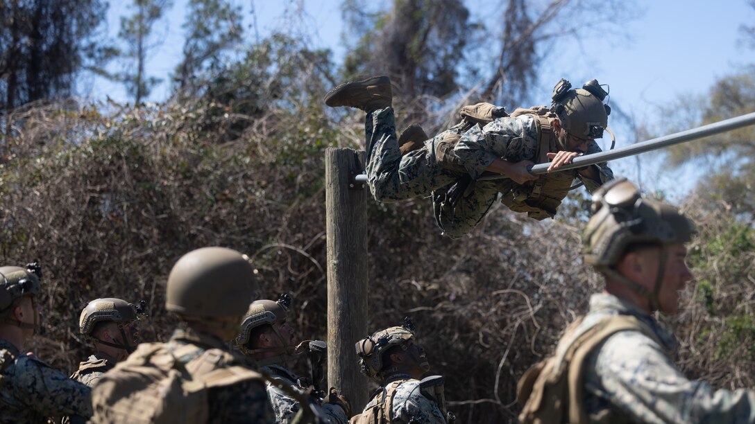U.S. Marines with 2d Battalion, 6th Marines, 2d Marine Division complete an obstacle course during the Infantry Squad Movement Evaluation on Marine Corps Base Camp Lejeune, North Carolina, March 21, 2025. The Infantry Squad Movement Evaluation evaluated the Marines on their physical fitness, weapons knowledge and teamwork in order to promote a competitive environment and promote the warrior spirit. (U.S. Marine Corps photo by Lance Cpl. Abram Maestre)