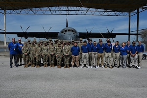 Local high school Junior Reserve Officer Training Corps cadets take a group photo in front of a C-130J Super Hercules.