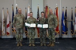 U.S. Army Brig. Gen. Jason Fryman, the commanding general of the Georgia Army National Guard, joins Command Sgt. Maj. John Ballenger, state command sergeant major of Georgia Army National Guard, in awarding 2025 Georgia Army National Guard Best Warrior Competition noncommissioned officer of the year, U.S. Army Sgt. Nicolas White, and 2025 Georgia Army National Guard Best Warrior Competition Soldier of the year, Georgia Defence Force Cpl. Dachi Matiashvili, during an award ceremony at Clay National Guard Center, Marietta, Georgia, March 13, 2025. The competition demonstrates the readiness and lethality of Georgia Army National Guard Soldiers by testing the competitors with physical fitness assessments, written exams, and other warrior tasks and battle drills. (U.S. Army National Guard photo by Spc. Alexandria Amos)