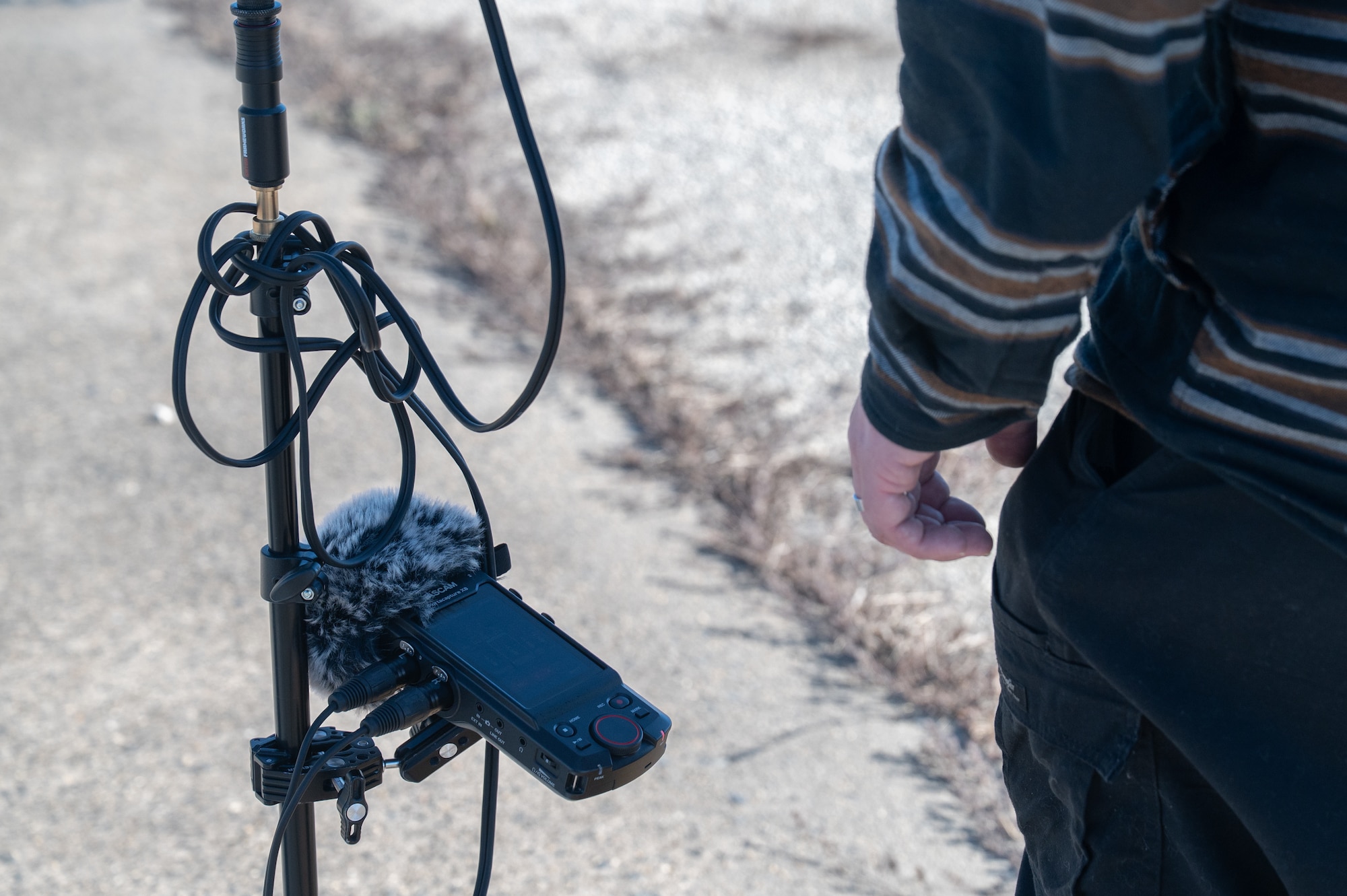 A microphone stands on display on a tripod stand.