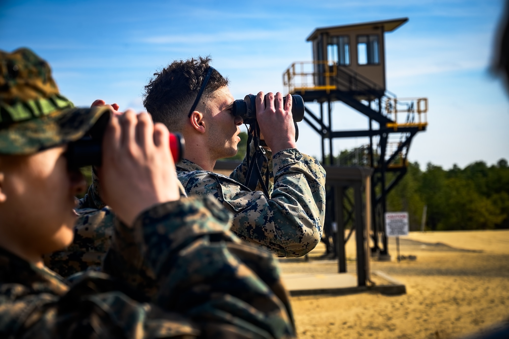 U.S. Marine Corps Cpls. Blake Albright and Lucas Hong, 25th Marine Regiment, 4th Marine Division, Marine Forces Reserve, fire support marines, observe target locations for air strikes during a close air support exercise training at Joint Base McGuire-Dix-Lakehurst, N.J., March 14, 2025. JTACs assigned to the 25th Marine Regiment conducted a training for recertification, which included both live target coordinated air and artillery strikes. A JTAC is a qualified service member who directs the action of military assets engaged in close land and air support for offensive operations from a forward position. (U.S. Air Force photo by Senior Airman Matt Porter)