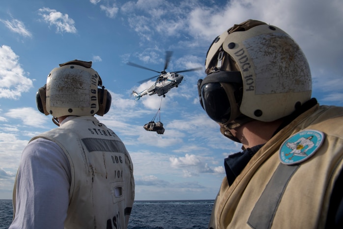 250226-N-FH842-1003 PHILIPPINE SEA (Feb. 26, 2025) – Lt. j.g. Andrew Koonz, of Imperial Beach, Fla., left, and Hospital Corpsman 2nd Class Cameron Sanders, of Murfreesboro, Tenn., observe a Military Sealift Command AS-322 Puma helicopter transporting cargo to the flight deck aboard the Arleigh Burke-class guided-missile destroyer USS Sterett (DDG 104) during a vertical replenishment with the Lewis and Clark-class dry cargo and ammunition ship USNS Charles Drew (T-AKE 10), Feb. 26, 2025. The Carl Vinson Carrier Strike Group is underway conducting routine operations in the U.S. 7th Fleet area of operations. (U.S. Navy photo by Mass Communication Specialist 3rd Class Brianna Walker)