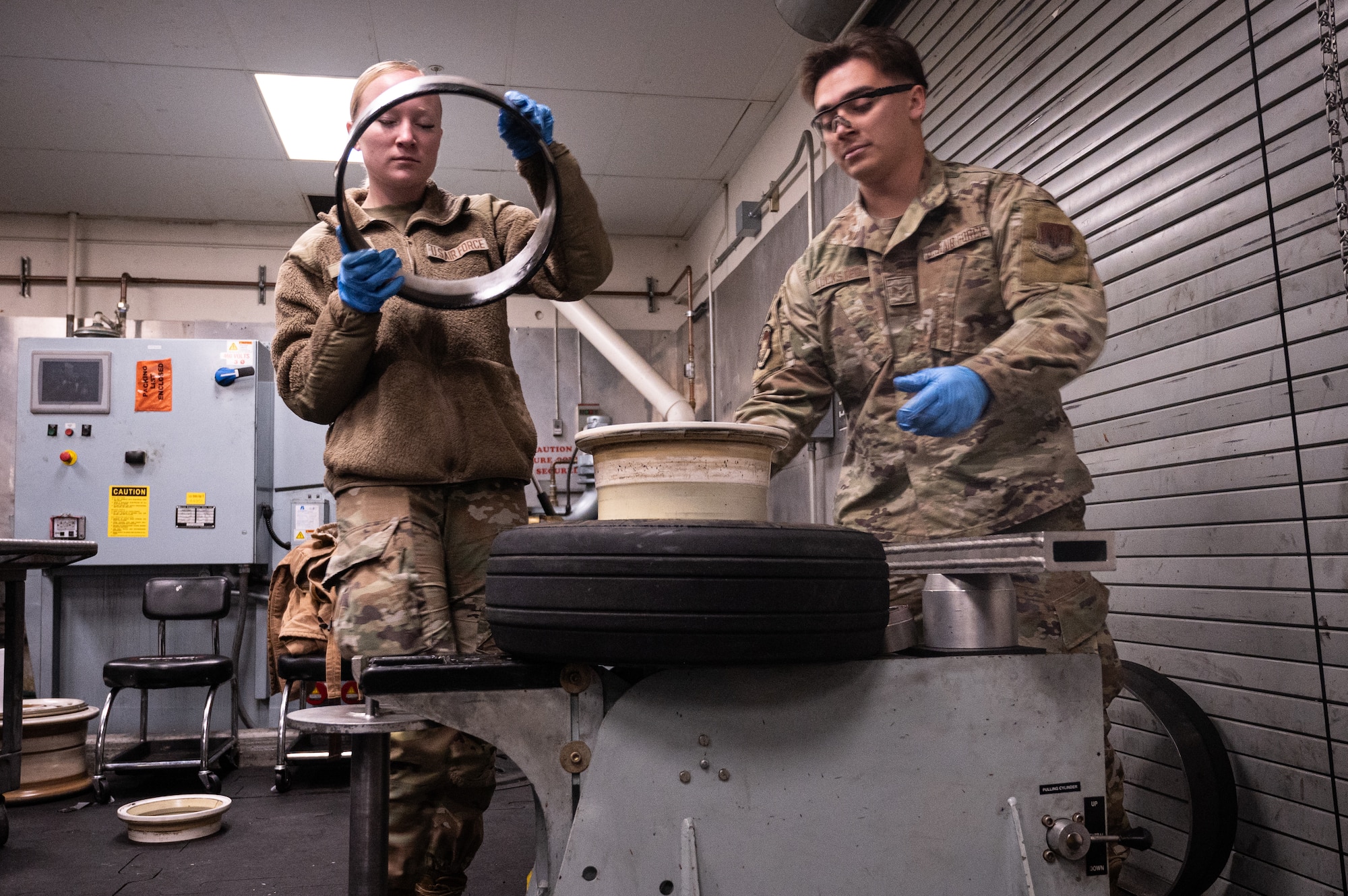 A photo of Airmen replacing a tire on an F-35 wheel