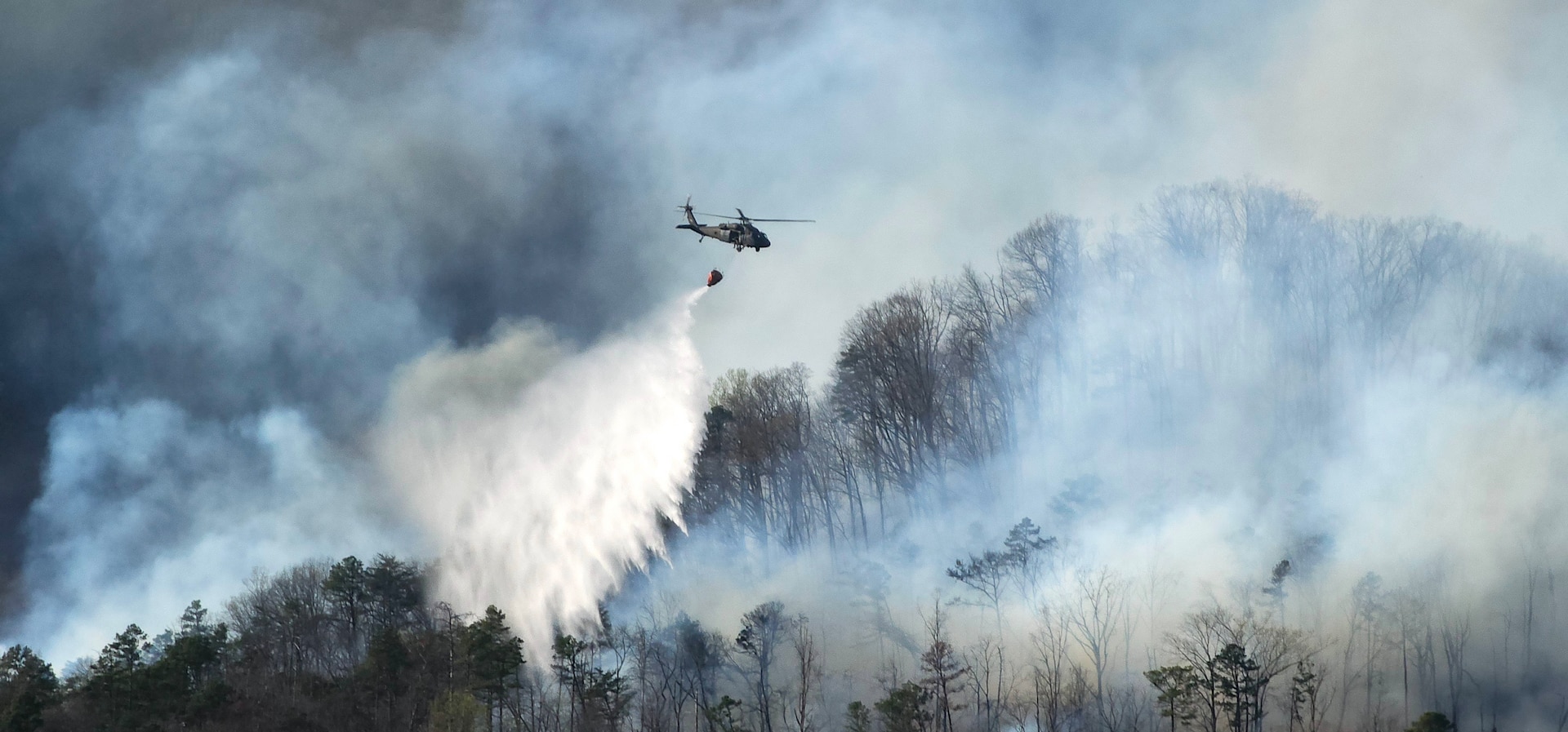 South Carolina Army National Guard UH-60 Black hawk and  CH-47 Chinook helicopters conduct aerial, water-bucket operations on the Table Rock and Persimmon Ridge wildfires in Pickens County, South Carolina March 23, 2025.
