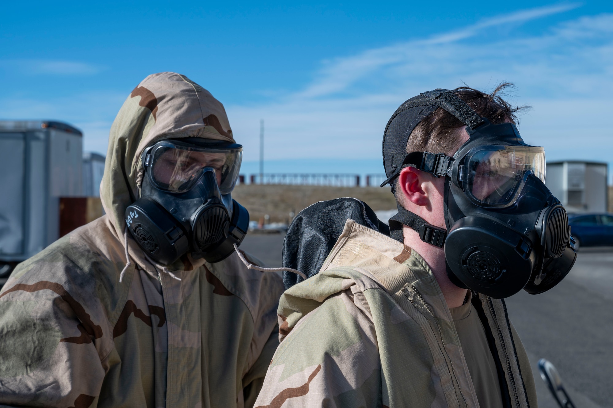 U.S. Air Force Airman 1st Class Michael Antonellis and Airman 1st Class Kenneth Armstead, emergency management specialists assigned to the 92nd Civil Engineer Squadron, utilize the buddy system to remove mission oriented protective posture gear at Fairchild Air Force Base, Washington, Feb. 22, 2025. MOPP gear provides a critical barrier against chemical, biological, radiological, and nuclear agents, safeguarding the health and operational readiness of military personnel in contaminated environments. (U.S. Air Force photo by Airman 1st Class Samantha Thorn)