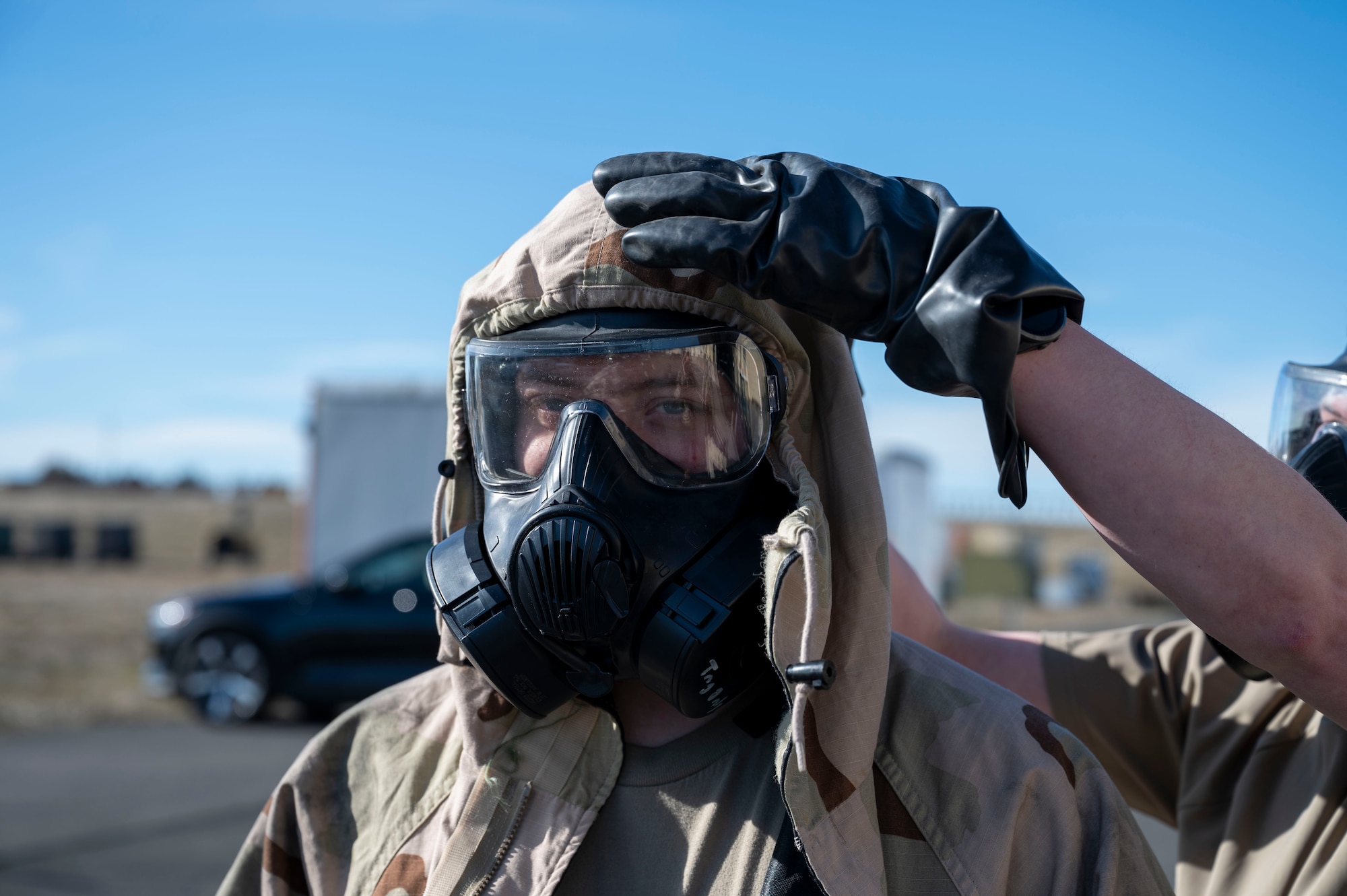 U.S. Air Force Airman 1st Class Michael Antonellis and Airman 1st Class Kenneth Armstead emergency management specialists assigned to the 92nd Civil Engineer Squadron, utilize the buddy system to remove mission oriented protective posture gear at Fairchild Air Force Base, Washington, Feb. 22, 2025. MOPP gear provides a critical barrier against chemical, biological, radiological, and nuclear agents, safeguarding the health and operational readiness of military personnel in contaminated environments. (U.S. Air Force photo by Airman 1st Class Samantha Thorn)