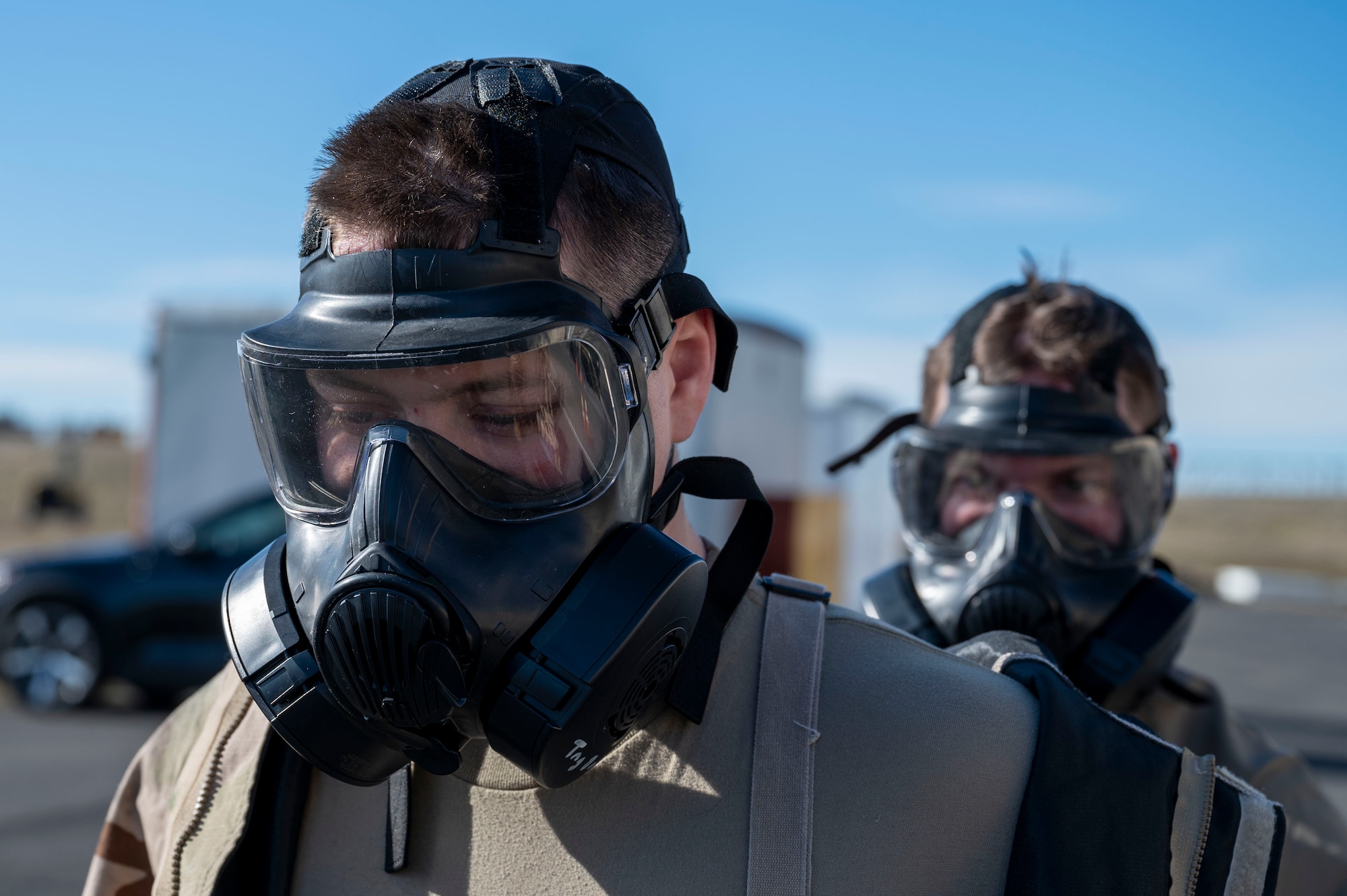 U.S. Air Force Airman 1st Class Michael Antonellis and Airman 1st Class Kenneth Armstead emergency management specialists assigned to the 92nd Civil Engineer Squadron, utilize the buddy system to remove mission oriented protective posture gear at Fairchild Air Force Base, Washington, Feb. 22, 2025. MOPP gear provides a critical barrier against chemical, biological, radiological, and nuclear agents, safeguarding the health and operational readiness of military personnel in contaminated environments. (U.S. Air Force photo by Airman 1st Class Samantha Thorn)