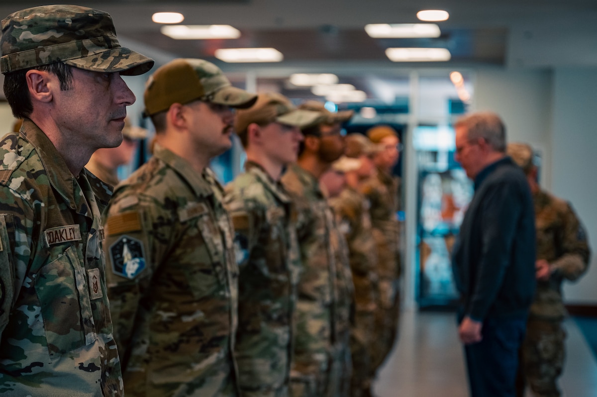 service members standing in formation being inspected by two people
