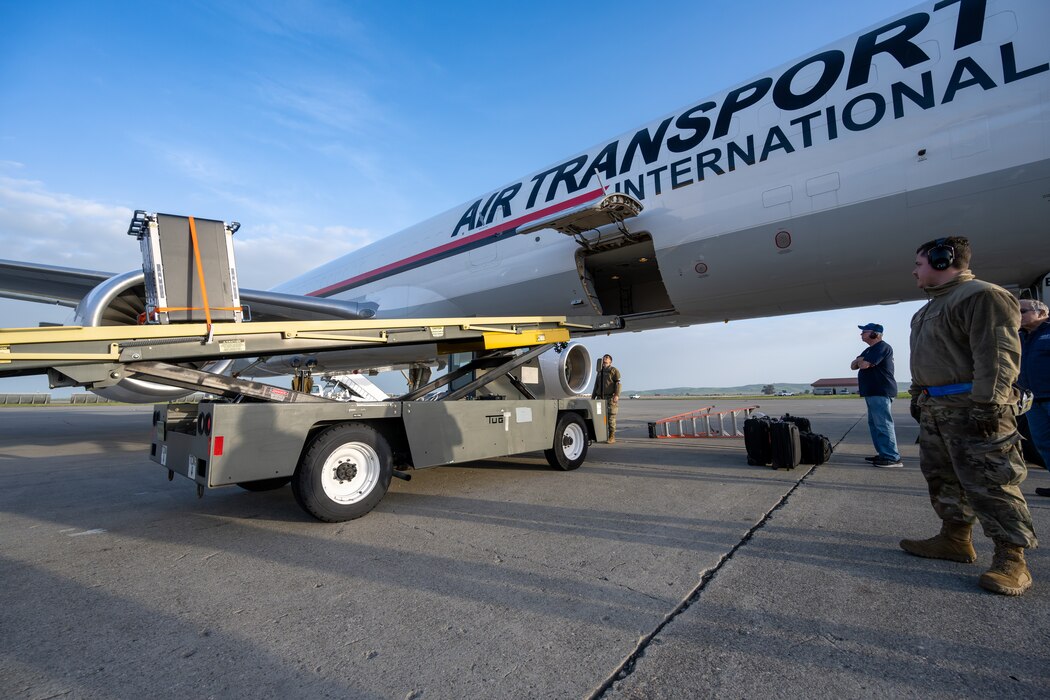A truck pulls up to an airplane on the flight line