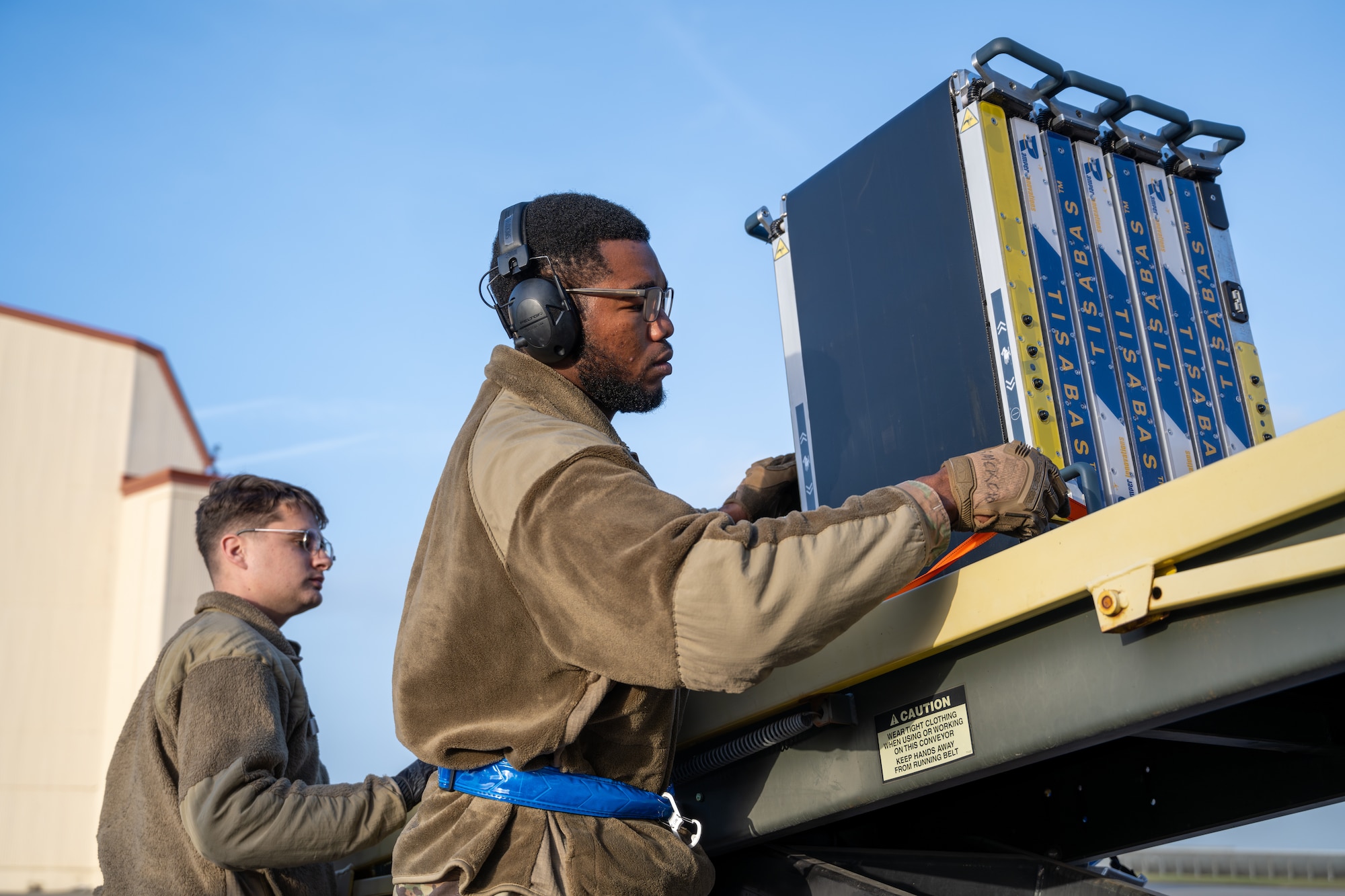 Airmen load cargo on a 60k-tonner loader