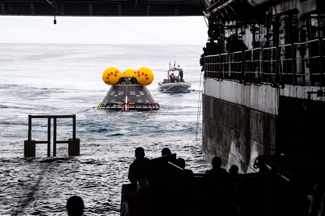Sailors assigned to amphibious transport dock USS Somerset (LPD 25) and NASA engineers release a crew module test article from the ship’s well deck during NASA Underway Recovery Test 12 in the Pacific Ocean, March 26, 2025.