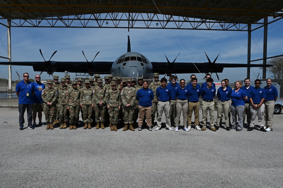 Local high school Junior Reserve Officer Training Corps cadets take a group photo in front of a C-130J Super Hercules.
