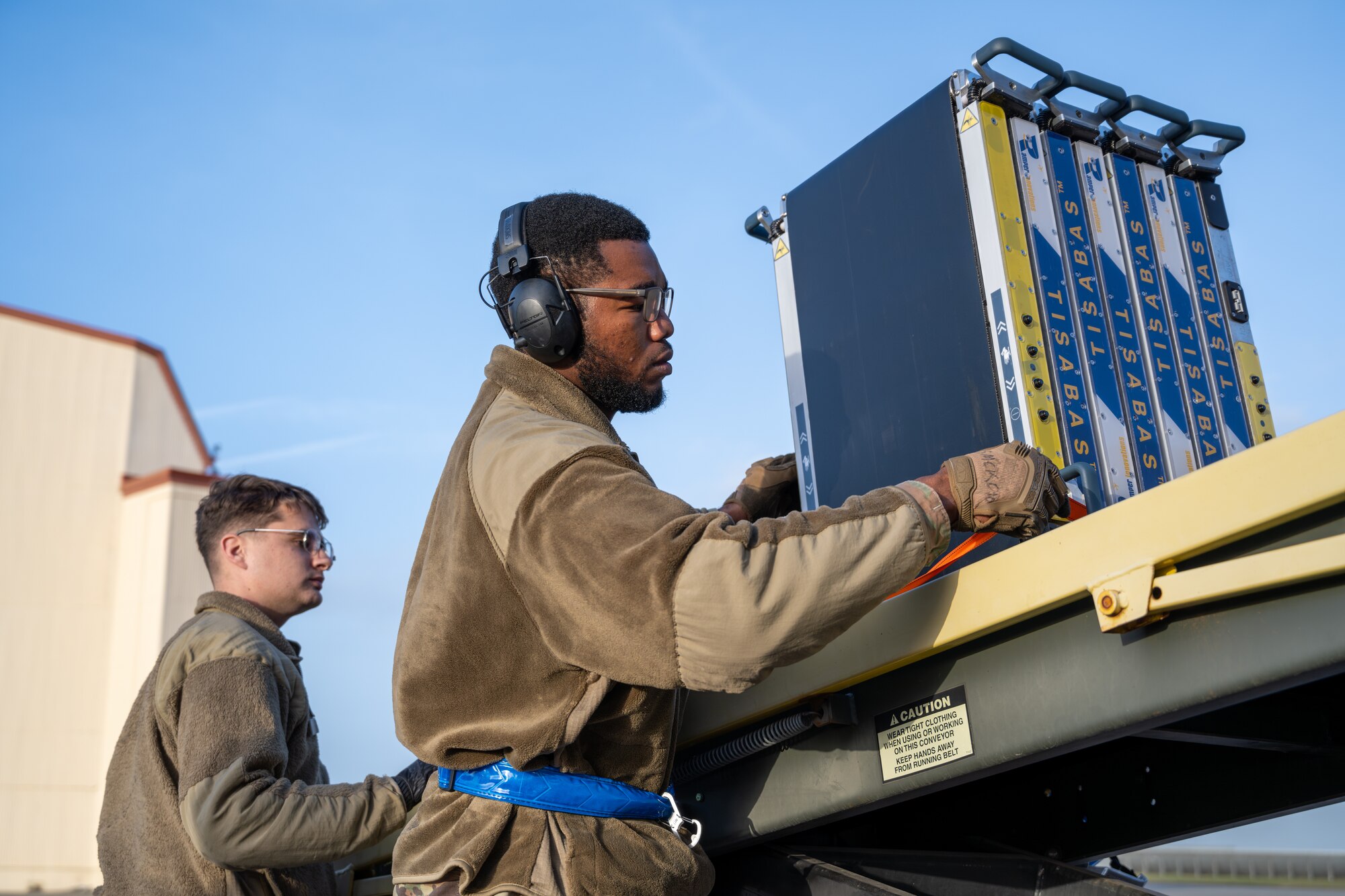 Airmen load cargo on a 60k-tonner loader