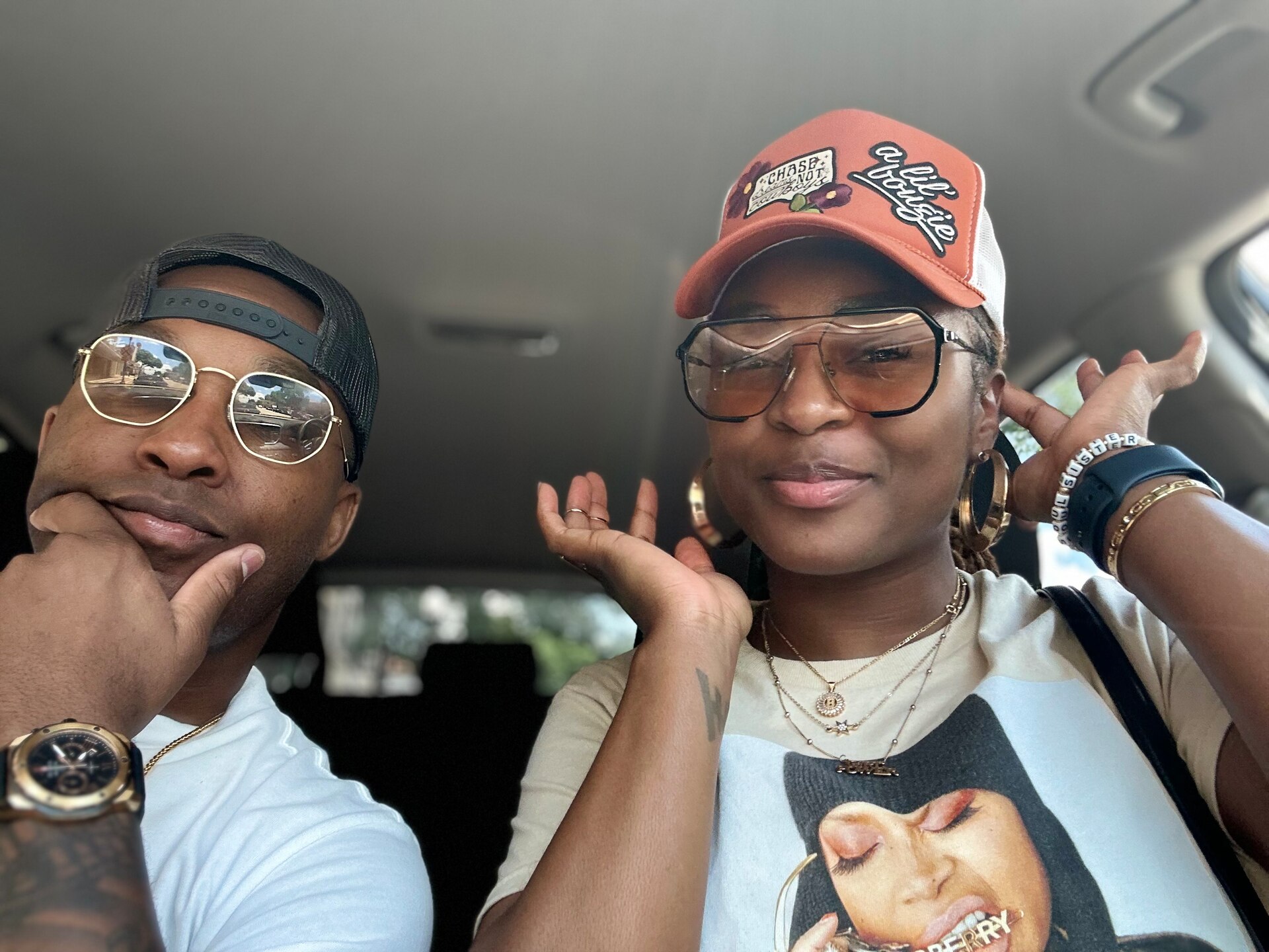 Husband and wife pose together for a car selfie.