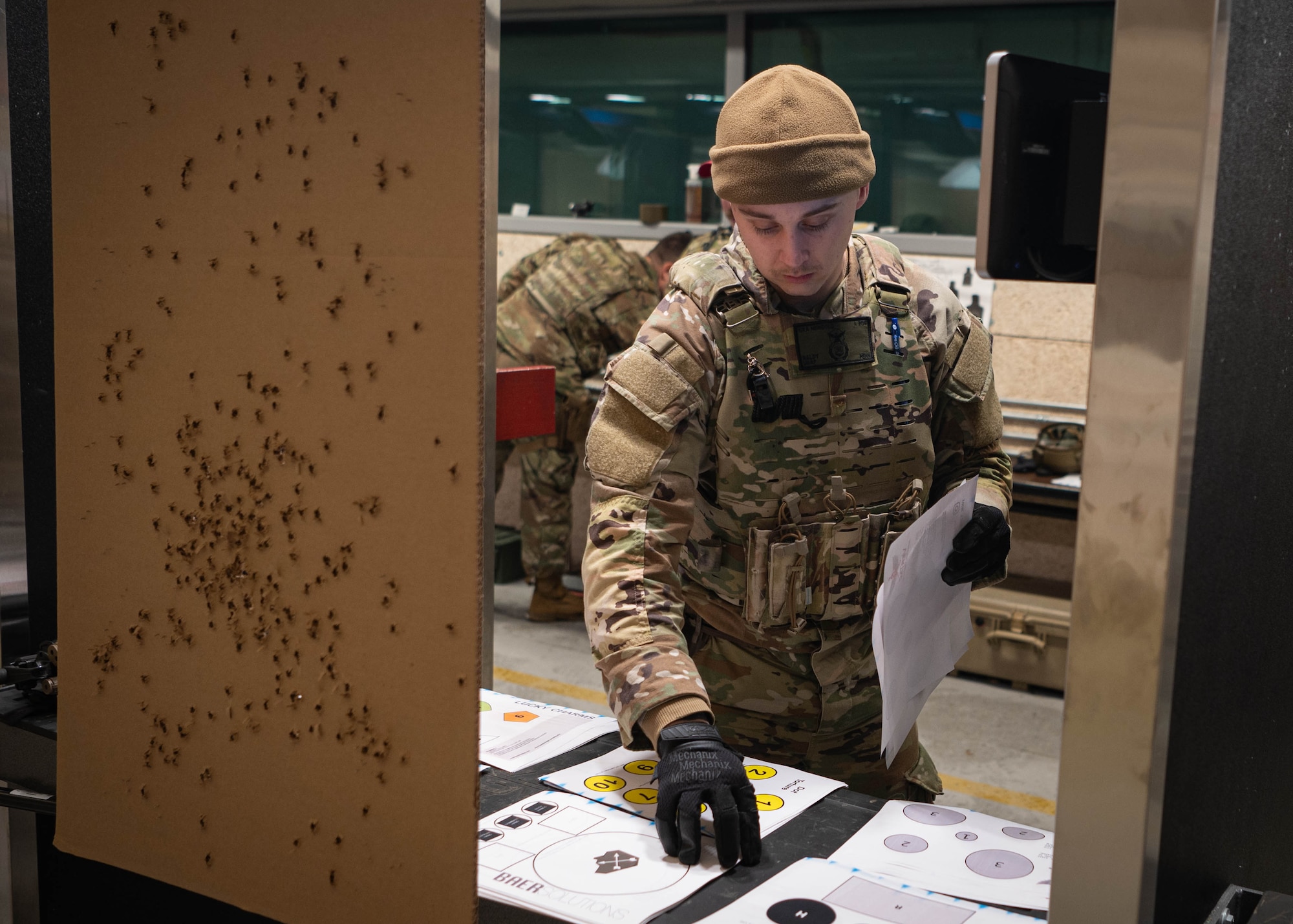 Senior Airman Tyler Newbold, 55th Security Forces Squadron defender and Savage Raider Team candidate, grabs paper targets in preparation for the shooting portion of SRT tryouts at the Offutt firing range March 5, 2025. Candidates were evaluated on their weapon handling and shooting skills for the M4 rifle and M18 handgun. (U.S. Air Force photo by Daniel Martinez)
