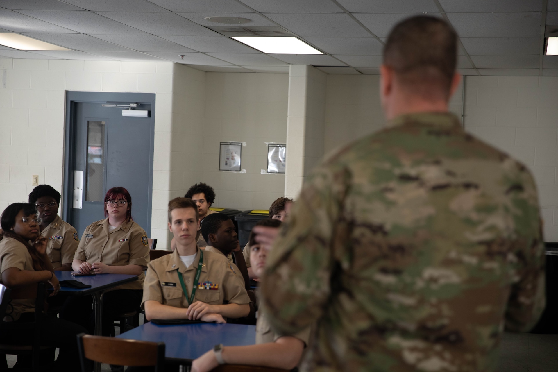 Cadets with Shawnee Academy’s JROTC program listen to Chief Warrant Officer 3 William Cottrell speak prior to the tour of the Kentucky Army National Guard’s Maneuver Area Training Equipment Site (MATES), Mar. 12. The students took part in a hands-on tour of the facilities. They explored maintenance shops, logistics areas, and got up close with military equipment. (U.S. Army photo by Milt Spalding)